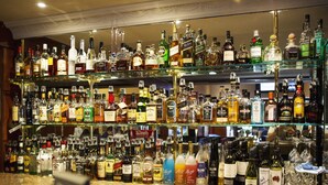 A bar with multiple shelves stocked with various liquor bottles. - Nightcap at Blue Cattle Dog Hotel (St Clair)