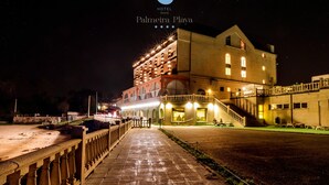 A hotel with a prominent entrance, a well-lit facade, and a pathway leading to the building. - Hotel Norat Palmeira Playa (Ribeira)
