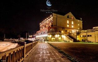 Um hotel com entrada destacada, fachada bem iluminada e um caminho que leva ao edifício.