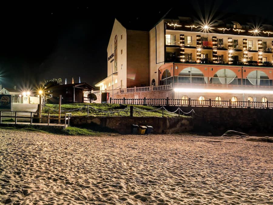 Un hotel con una torre destacada, varios balcones y una fachada bien iluminada.