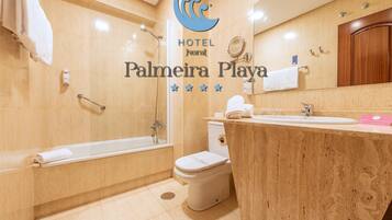 Un baño con bañera, inodoro y lavamanos.