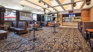 A hotel lobby with seating areas, a bar, and a television screen. - Nightcap at the Ranch Hotel (Marsfield)