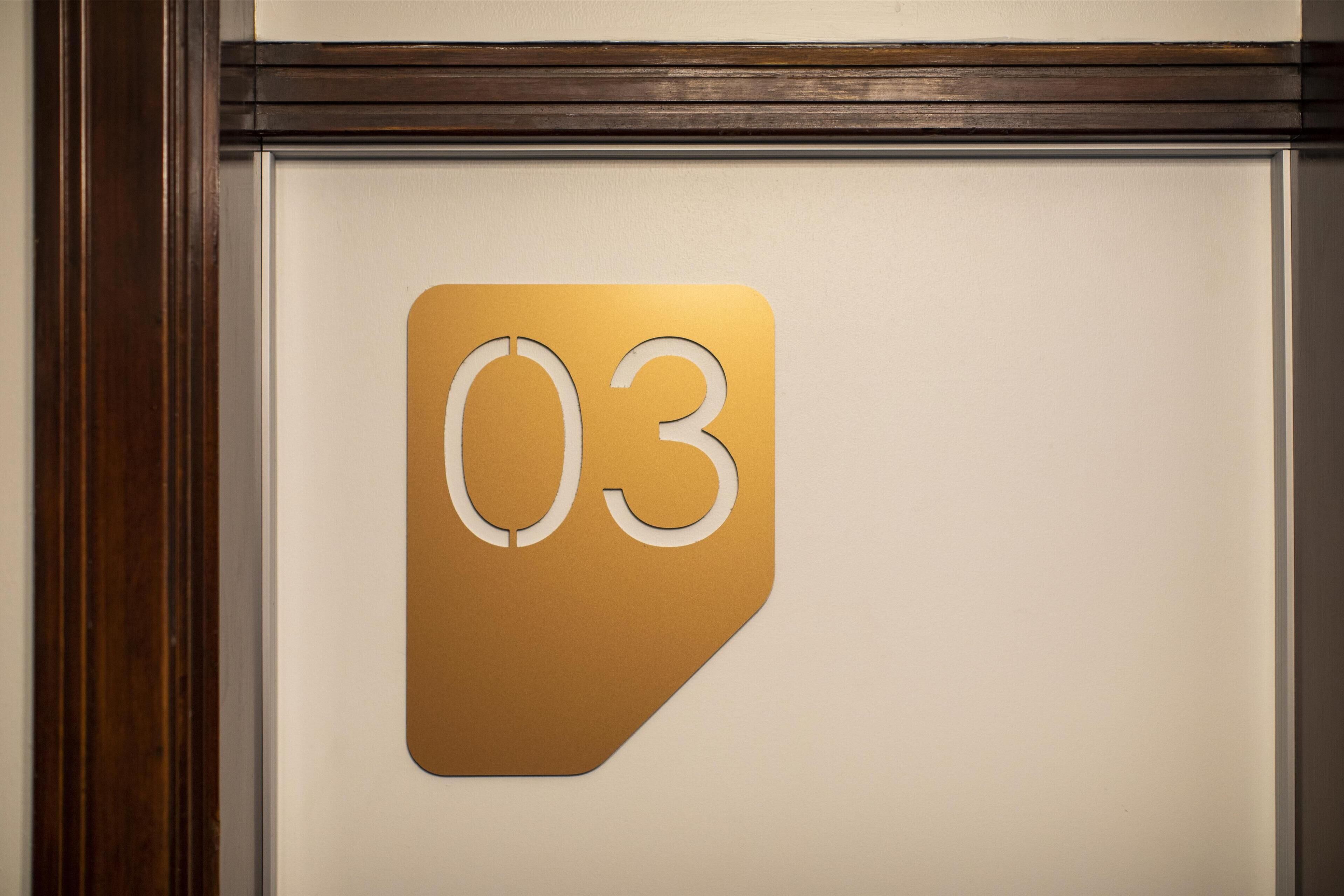 A wall-mounted sign with the number 03.