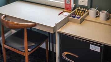 A desk with a chair, a coffee station, and a filing cabinet.