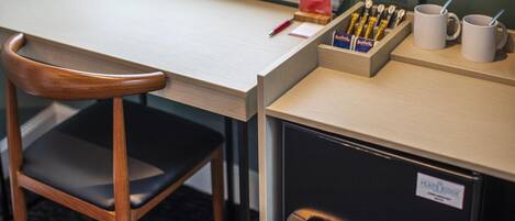 Un escritorio con una silla, una estación de café y un archivador.