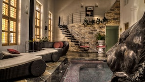 A luxurious indoor pool area with a stone wall, a staircase, and comfortable seating. - Casa de Leda, a Kali Hotel (Santa Marta)