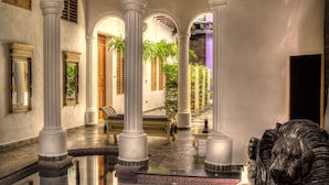 A spacious lobby with a tiled floor, white columns, and a decorative lion statue. - Casa de Leda, a Kali Hotel (Santa Marta)
