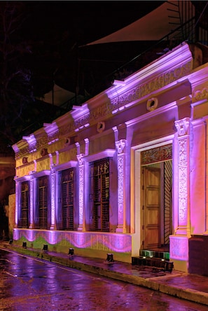 A building with ornate columns and decorative moldings, illuminated by purple lighting. - Casa de Leda, a Kali Hotel (Santa Marta)