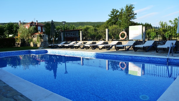 Une piscine avec des chaises longues et un cercle de sauvetage.