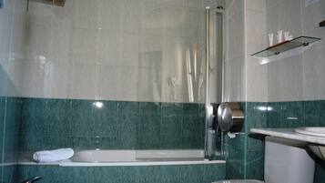 Un baño con bañera, inodoro y lavamanos.