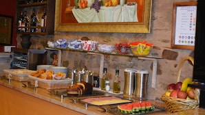 Un buffet proposant une variété de plats, notamment des fruits, des pâtisseries et des boissons.