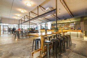 A spacious bar area with high stools, a long counter, and a well-lit ceiling with industrial-style lighting fixtures. - Nightcap at Ocean Beach Hotel (Umina Beach)