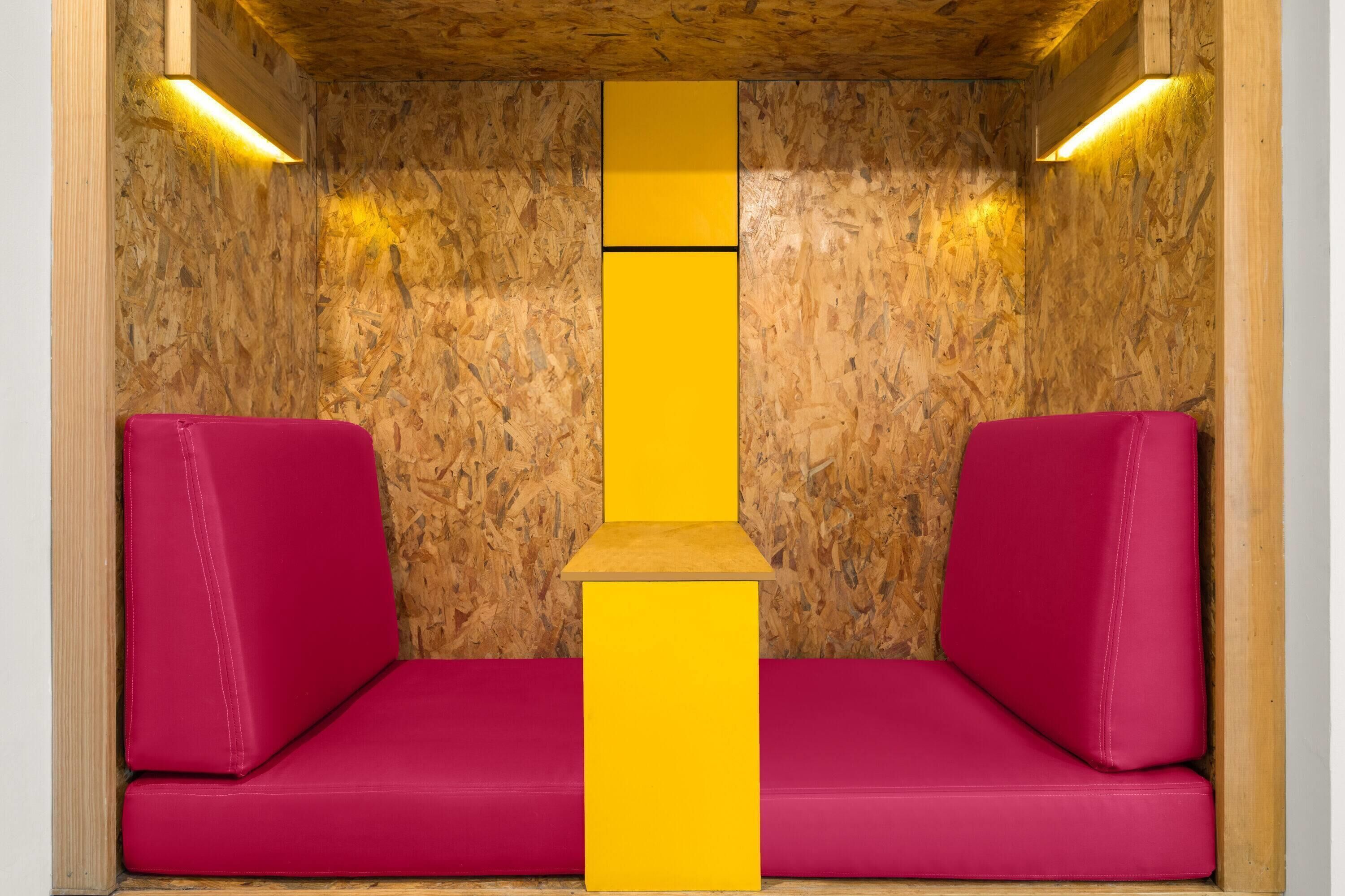 A small, enclosed space with a wooden wall and a central yellow pillar.