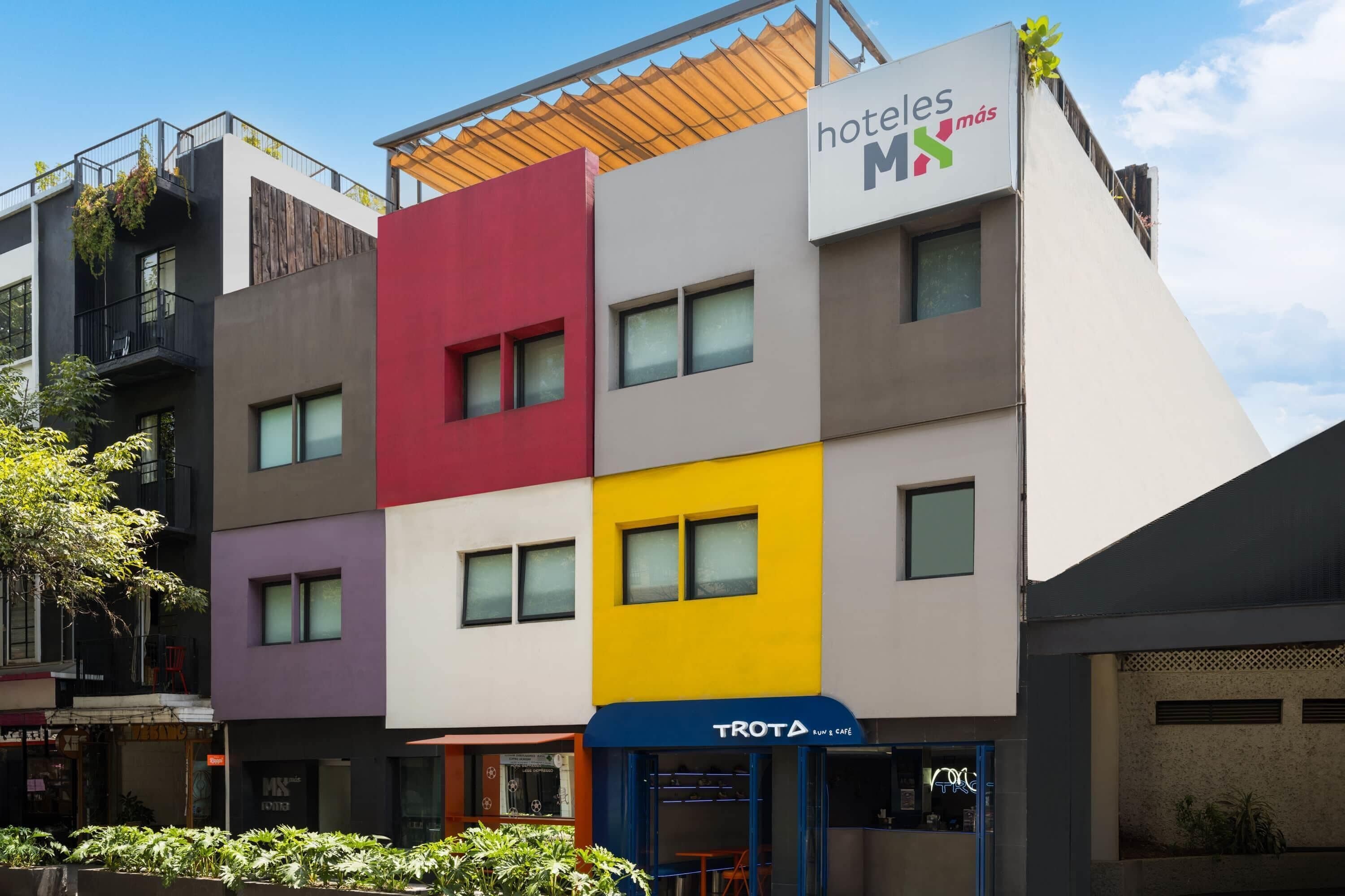 A multi-story hotel with a modern facade, featuring a mix of neutral and bright colors.