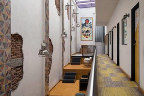 Un pasillo con un papel tapiz estampado, un mural y una escalera que lleva a una zona de estar.