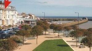 A coastal town with terraced houses, a promenade, and a pier. - Rowntree Holiday Flats (Bridlington)