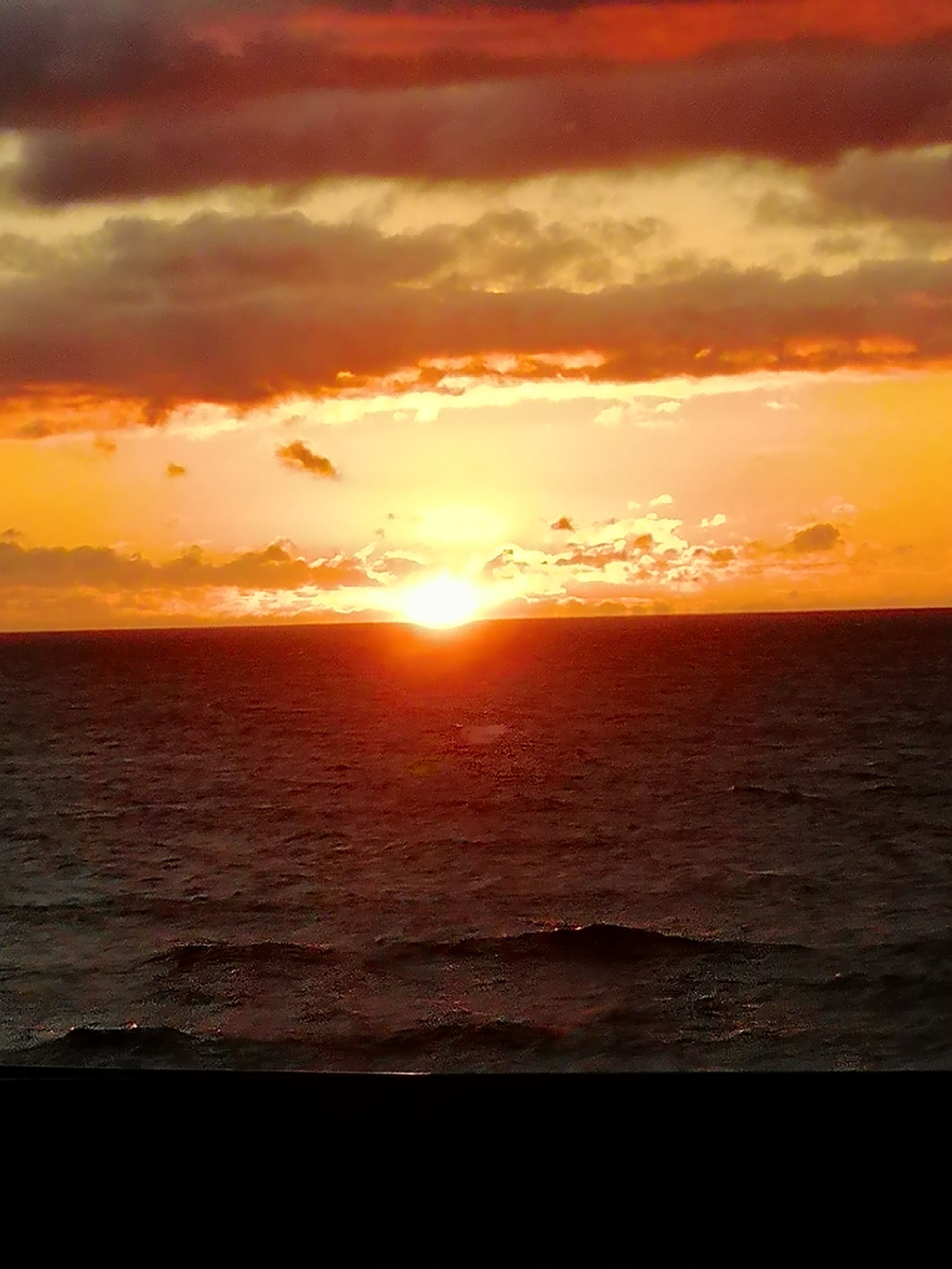 A sunset over the ocean with a clear horizon.