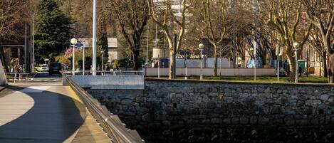 A bridge with a stone wall on one side and a body of water on the other.