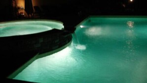 A swimming pool with a curved edge and a stone border. - Colombo Residence (Sorico)