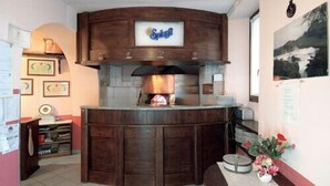 A wooden counter with a logo, a tiled floor, and a wall with framed certificates. - Colombo Residence (Sorico)