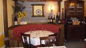 A round table with chairs, a wine rack, and a wall-mounted light fixture. - Colombo Residence (Sorico)
