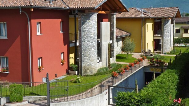 A hotel with a red and yellow facade, stone accents, and a welcoming entrance with a 'Welcome' sign. - Colombo Residence (Sorico)