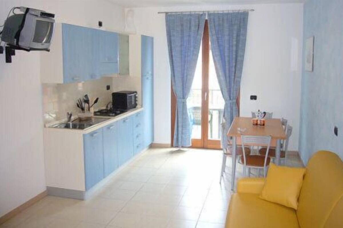 A compact living space with a kitchenette, a dining area, and a sofa.
