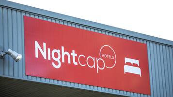 A red sign with the text "Nightcap Hotels" and a bed icon, indicating a hotel.