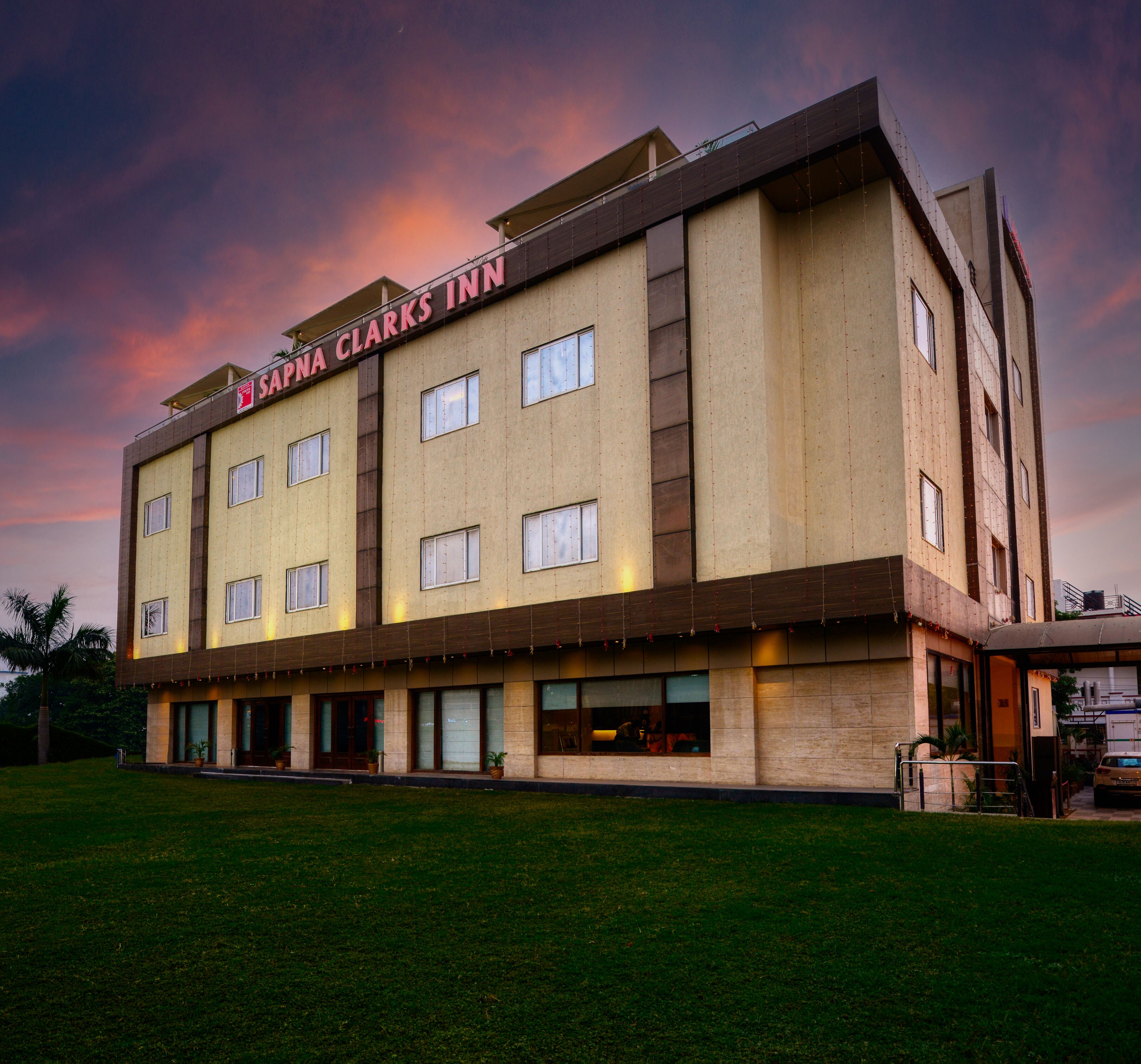 A multi-story hotel with a flat facade, large windows, and a sign reading "SAPA NA CLARKS INN".