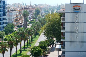 Un edificio de varios pisos con balcones y un letrero que dice 'GRAND OKAN'.