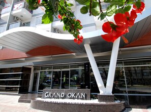 A modern building with a curved roof and a sign that reads "GRAND OKAN". - Grand Okan Hotel (Alanya)