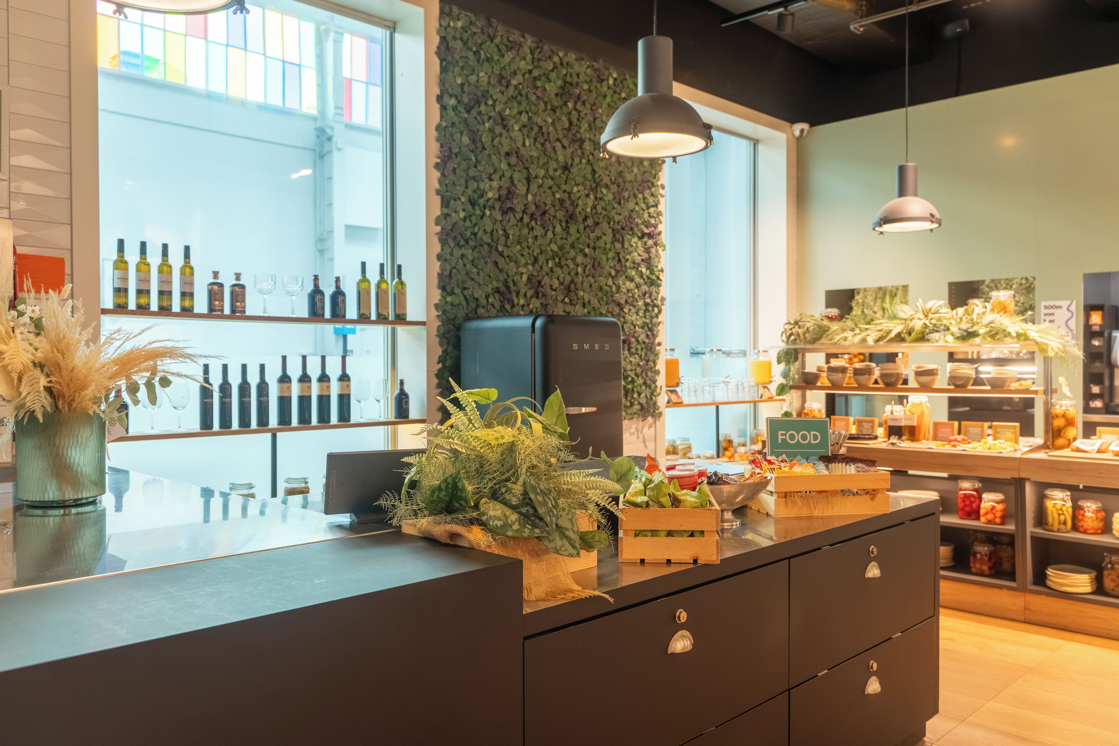 Un área de cocina moderna con una barra, un refrigerador y una variedad de alimentos y bebidas a la vista.