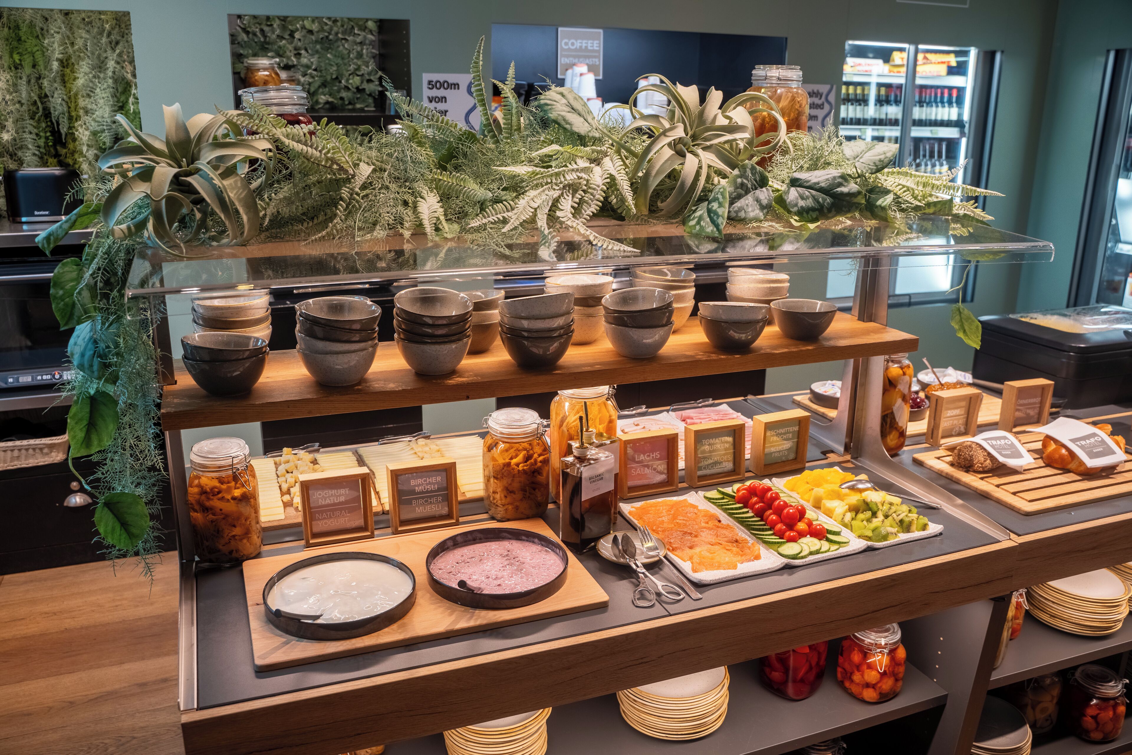 A buffet with various food items and condiments, including bowls, plates, and jars.
