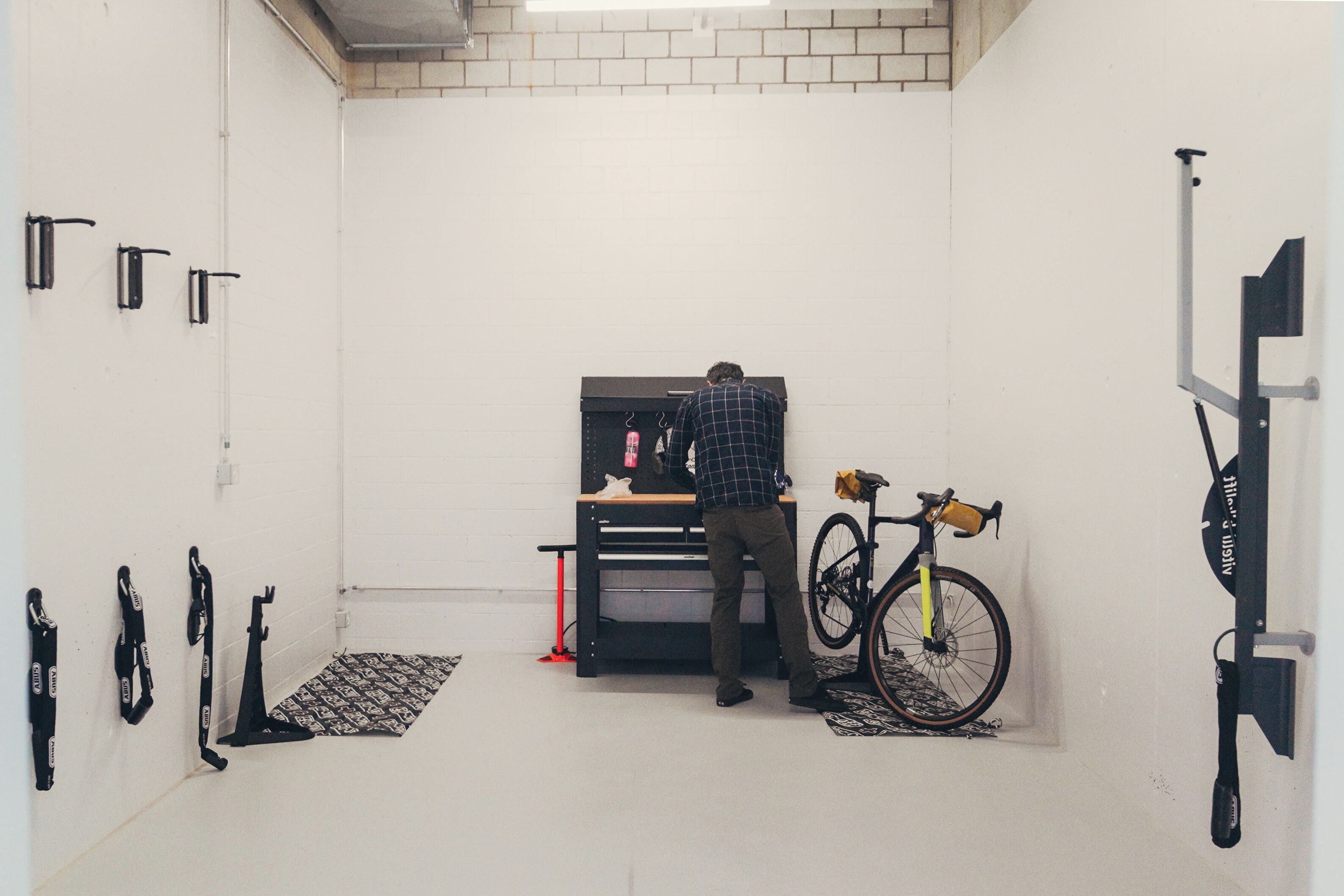 Una habitación con un archivador negro, una bicicleta y diversas herramientas en el suelo.