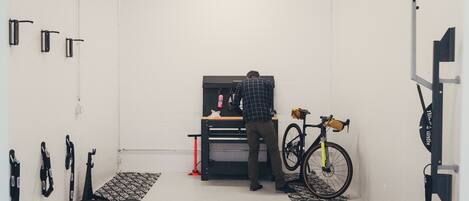 Una habitación con un archivador negro, una bicicleta y diversas herramientas en el suelo.