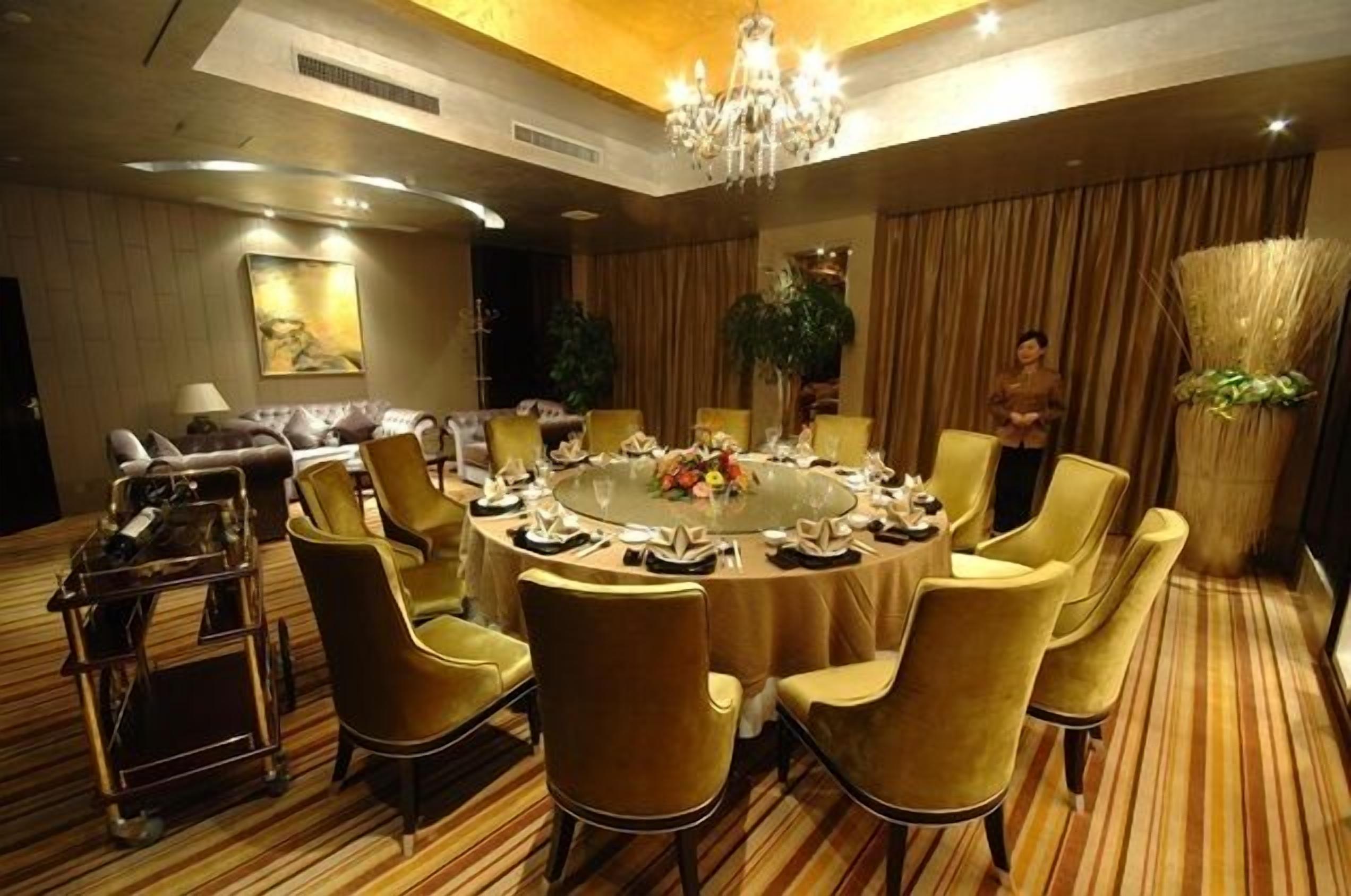 A conference room with a round table, chairs, and a chandelier.