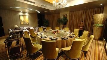 A conference room with a round table, chairs, and a chandelier.