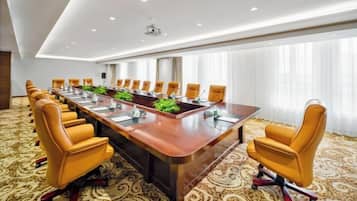 A conference room with a long table, multiple chairs, and a carpeted floor.