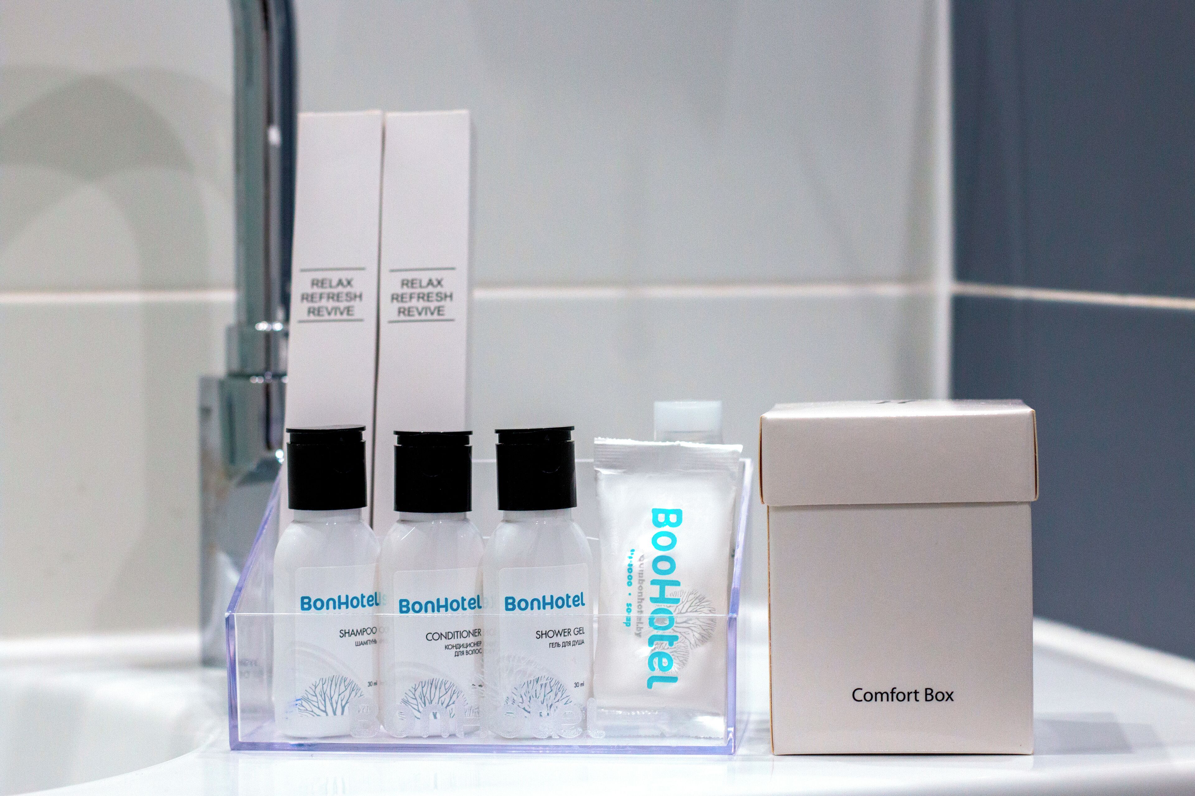 A bathroom with a clear display of BonHotel products including shampoo, conditioner, and shower gel.