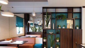 A modern restaurant with booths, tables, and hanging pendant lights. - Bonhotel (Minsk)