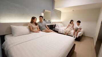 A hotel room with a large bed, a desk, and a mirror.