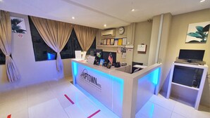 A hotel reception desk with a digital display, a clock, and framed certificates on the wall. - De UPTOWN Hotel @ Subang Jaya (Subang Jaya)