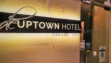 The exterior of the Uptown Hotel with a sign indicating room number 03-511.