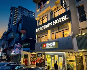 Das De Uptown Hotel mit einem Schild für Coco BBQ und ein Restaurant für gebratenes Seafood Chuan.