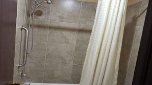A bathroom with a bathtub, a shower, and a toilet. - Executive Inn Woodward (Woodward)