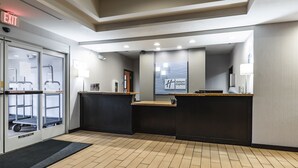 A hotel reception area with a reception desk, a digital display, and a glass door entrance. - Holiday Inn Express & Suites Ironton by IHG (Ironton)