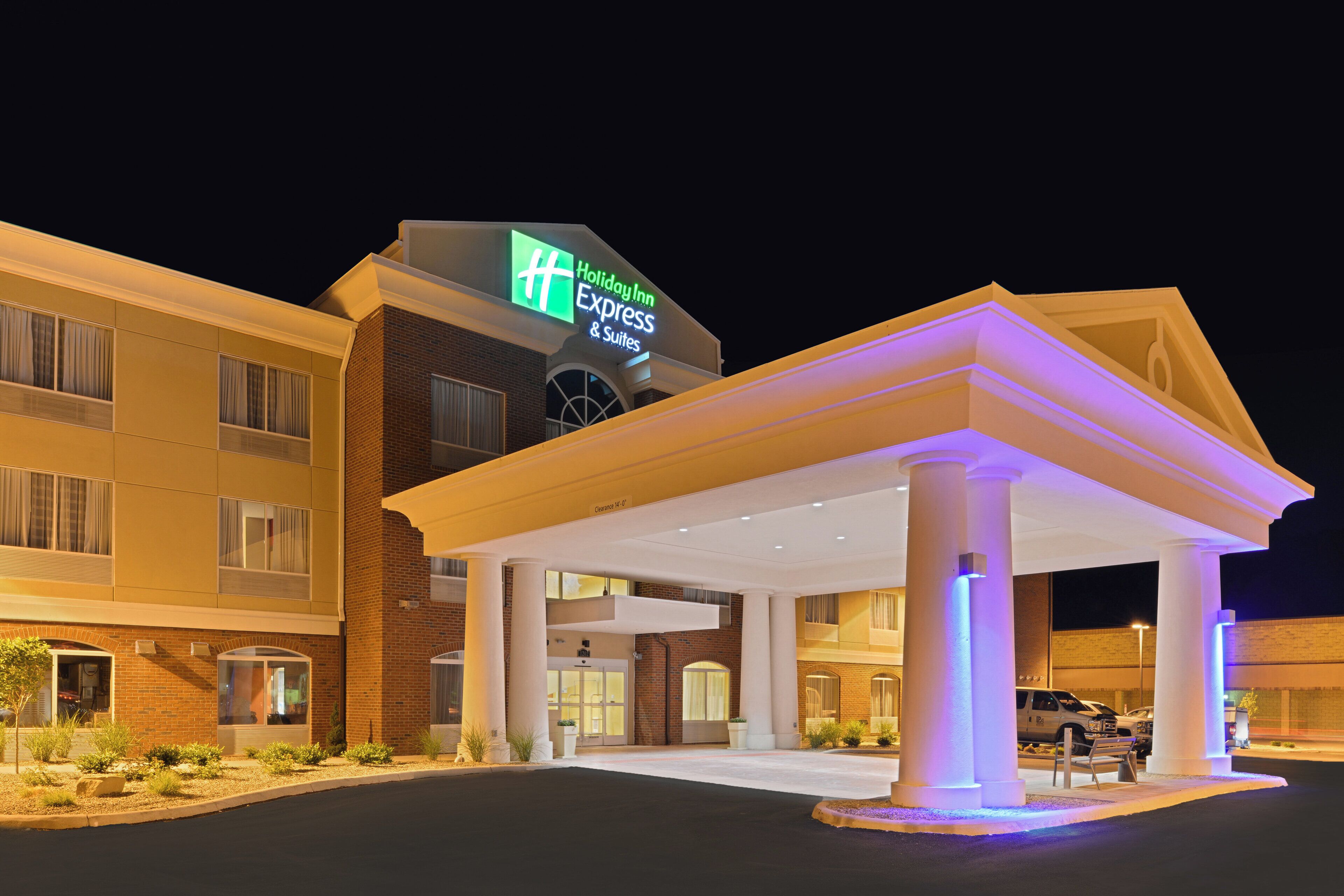 Ein Holiday Inn Express & Suites Hotel mit überdachter Eingangspartie und deutlicher Beschilderung.