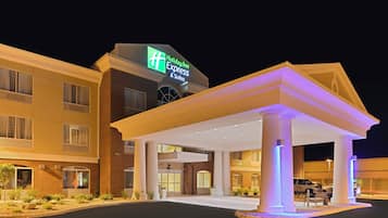 A Holiday Inn Express & Suites hotel with a covered entrance and a clear sign.