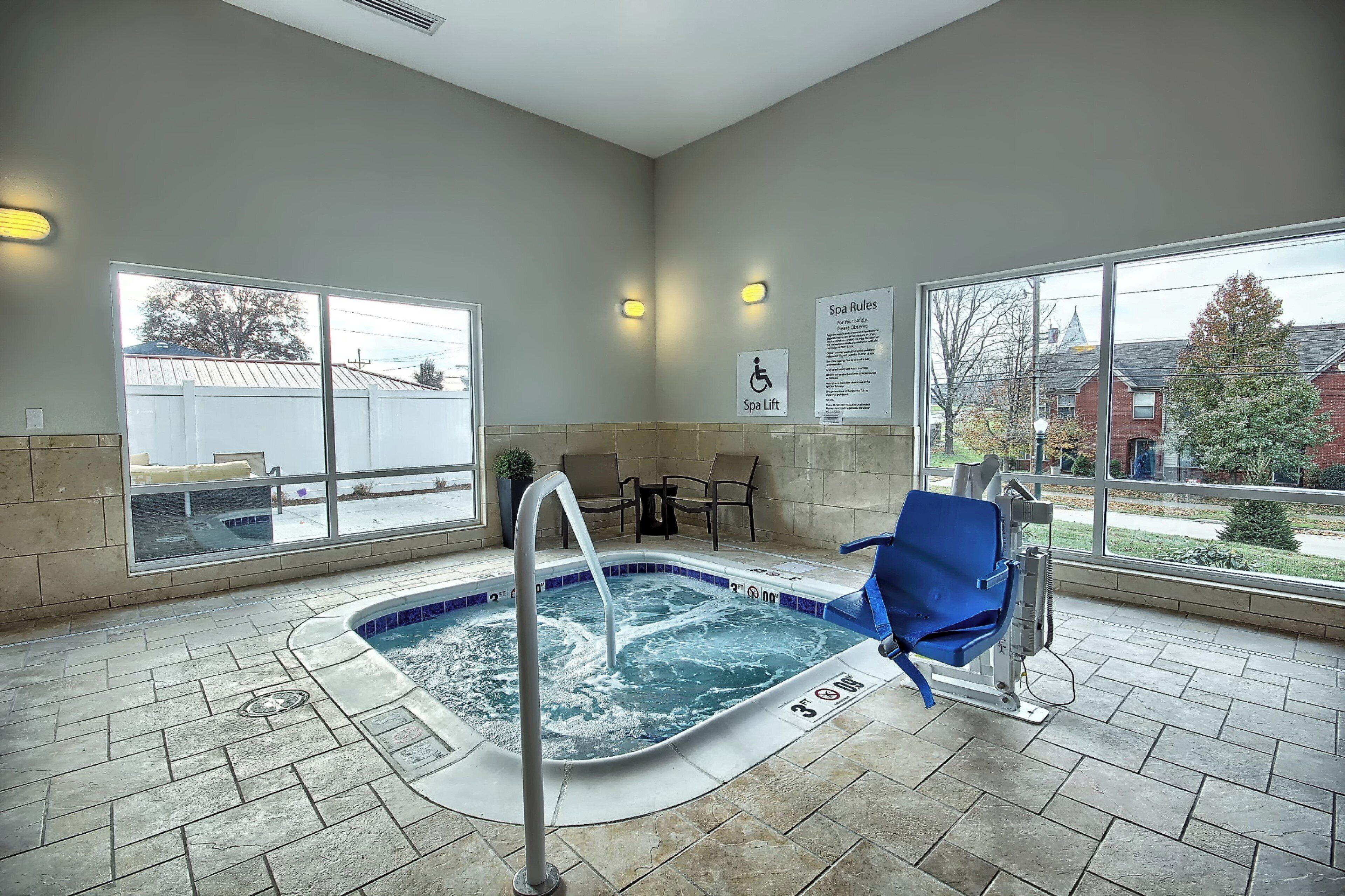 Zona de spa con hidromasaje, asientos y vistas al exterior.