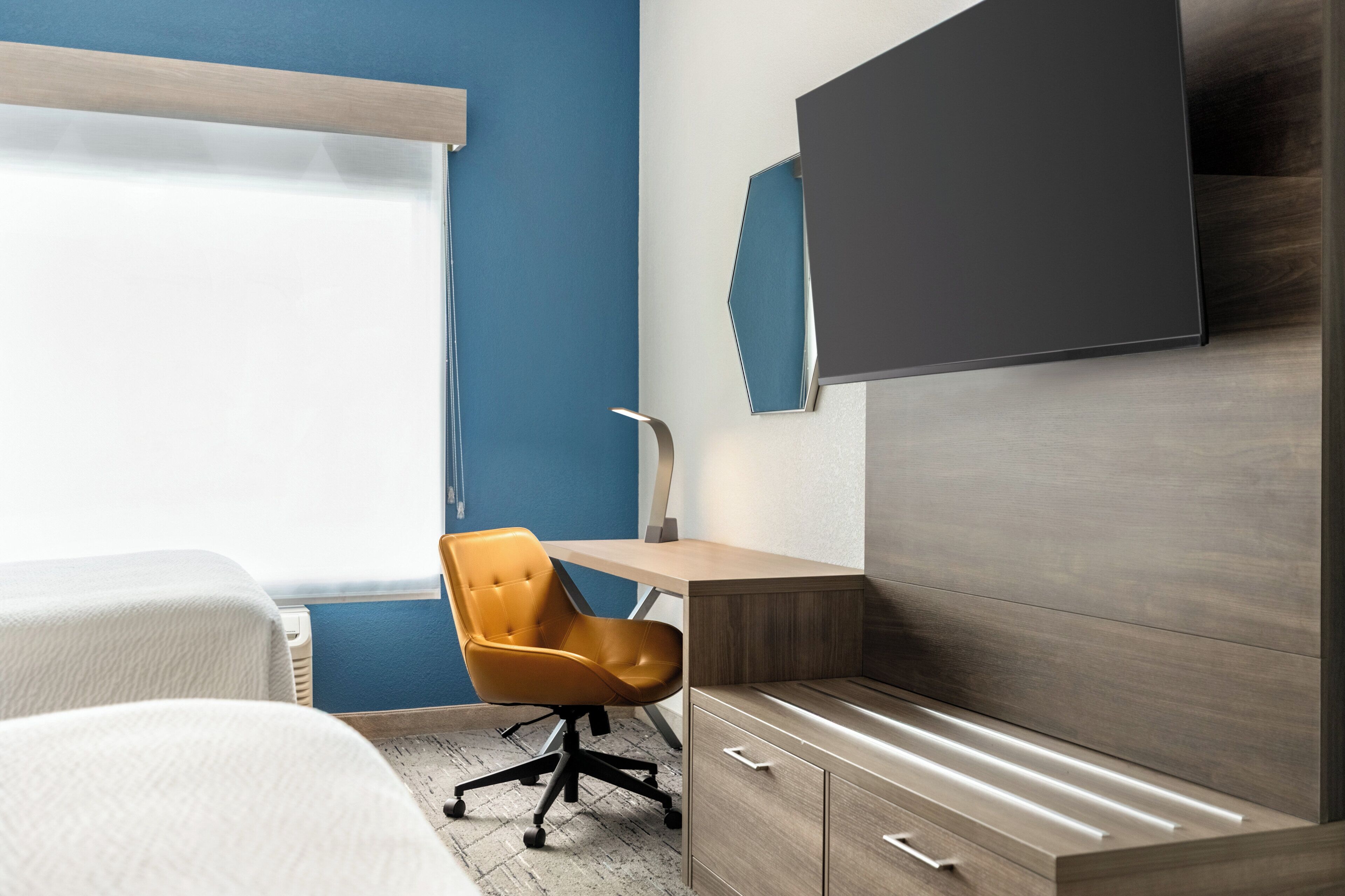 Ein modernes Schlafzimmer mit einem Bett, einem Schreibtisch und einem Stuhl.